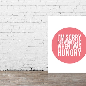 May include: A white canvas print with a pink circle in the center. The circle has the text "I'm sorry for what I said when I was hungry" in white.