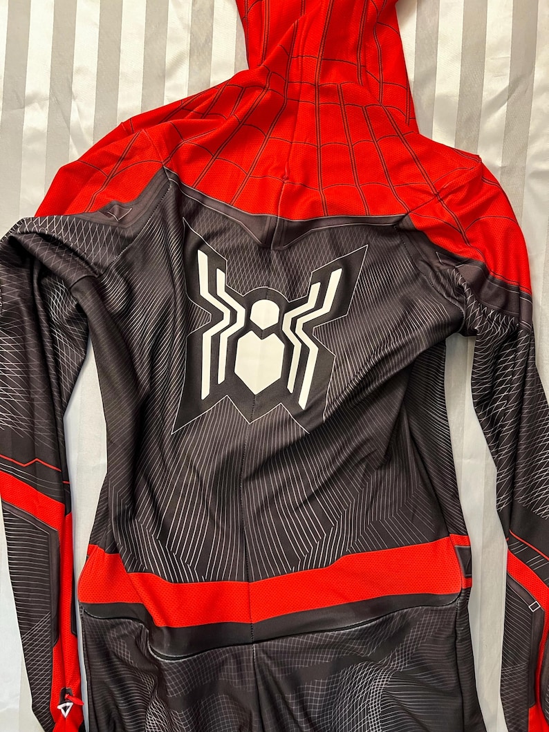 May include: Black and red Spiderman costume with a white spider logo on the back. The costume has a zip in the front and a hood.