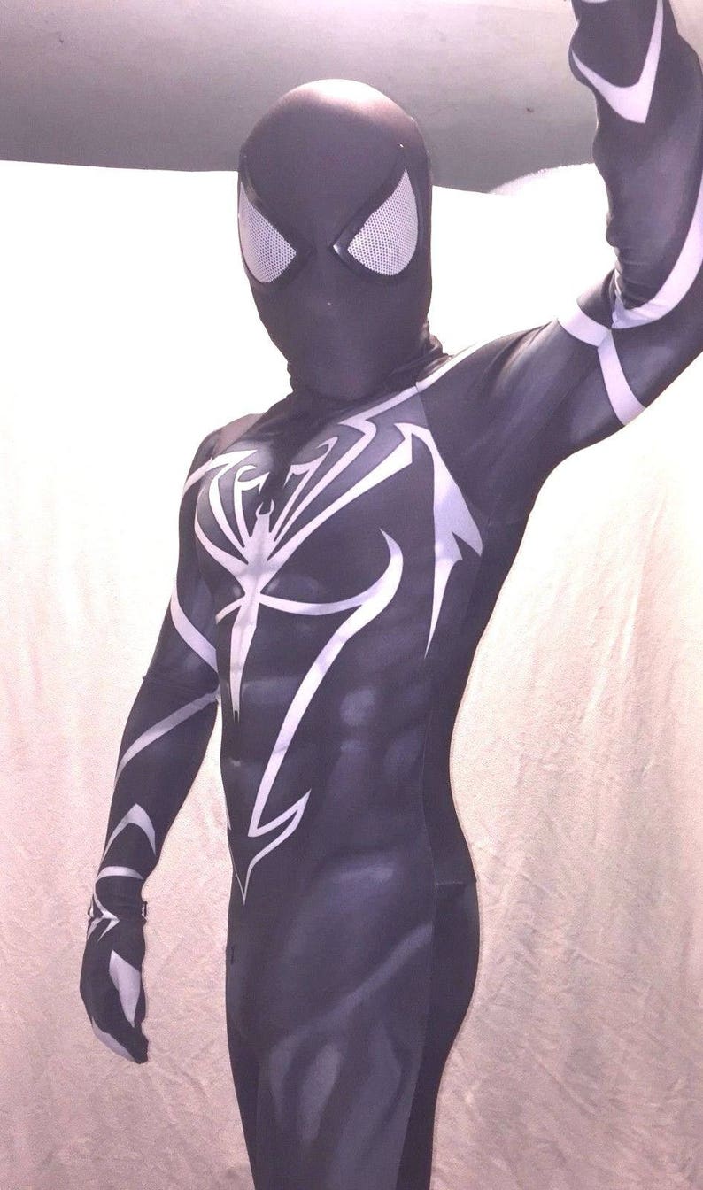 Może przedstawiać: Czarno-biały kostium z spandexu z wzorem pajęczyny. Kostium ma czarną maskę z białymi oczami.