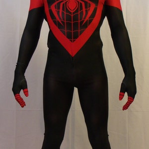 May include: A black and red spandex costume with a spider design on the chest. The costume has a black mask with a red spider design.