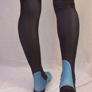 Puede incluir: Un par de medias negras con un dise&ntilde;o azul en los pies. Las medias est&aacute;n hechas de un material el&aacute;stico y tienen un patr&oacute;n de panal.