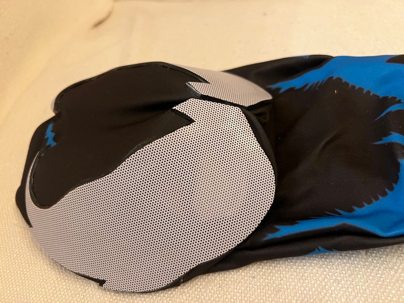 Puede incluir: Rodillera negra y azul con un panel de malla gris. La rodillera est&aacute; hecha de un material suave y transpirable y est&aacute; dise&ntilde;ada para brindar soporte y protecci&oacute;n.
