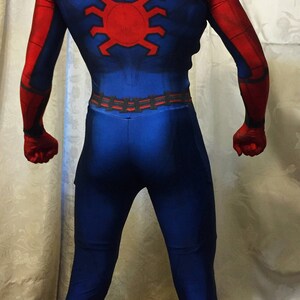 May include: A red and blue spandex costume with a spider design on the back. The costume has a black belt and red boots.