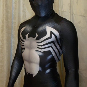 May include: A full-body black spandex suit featuring a textured honeycomb pattern throughout. The chest displays a large, white, stylized spider emblem. The headpiece includes a full-face mask with white, mesh-covered eye lenses.