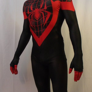 May include: A black and red spandex costume with a spider symbol on the chest. The costume has a black mask with a spider web design and white eyes.