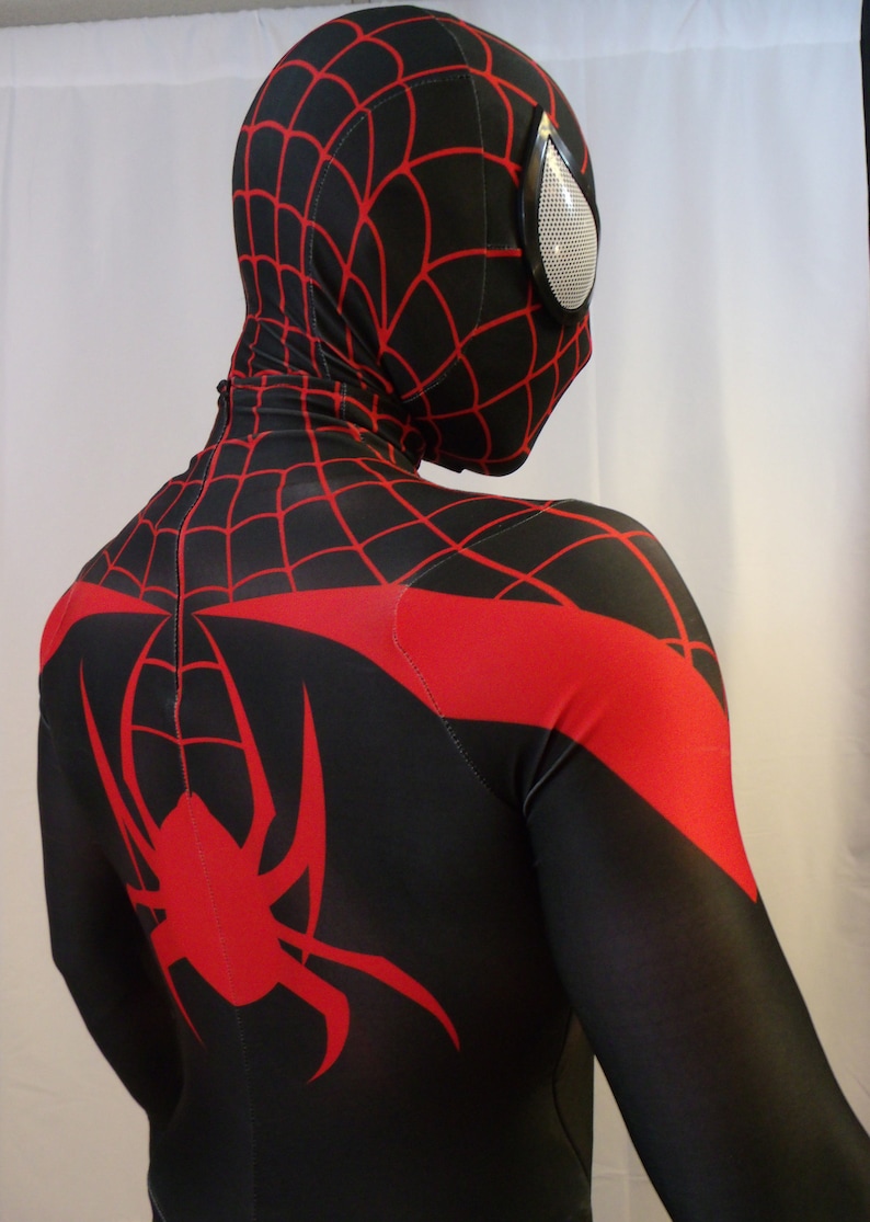 May include: A black and red spandex suit with a spider design on the back. The suit has a red spider web pattern on the chest and a black mask with a red spider web pattern.