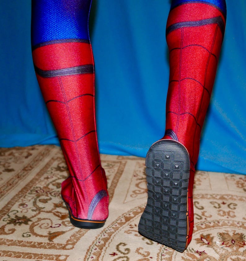 May include: A pair of red and blue spandex leggings with a spider web pattern. The leggings have black accents and a textured black sole.