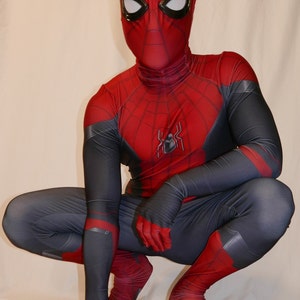 May include: A red and black spandex superhero costume with a spider logo on the chest. The costume has a mask with a red and black design and white eyes.