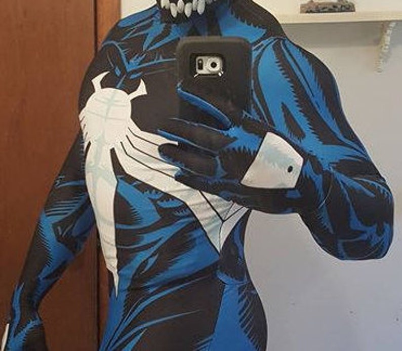 Puede incluir: Un mono de spandex azul y negro con un dise&ntilde;o de ara&ntilde;a blanco. El traje tiene una cremallera en la espalda y un s&iacute;mbolo blanco en el pecho.
