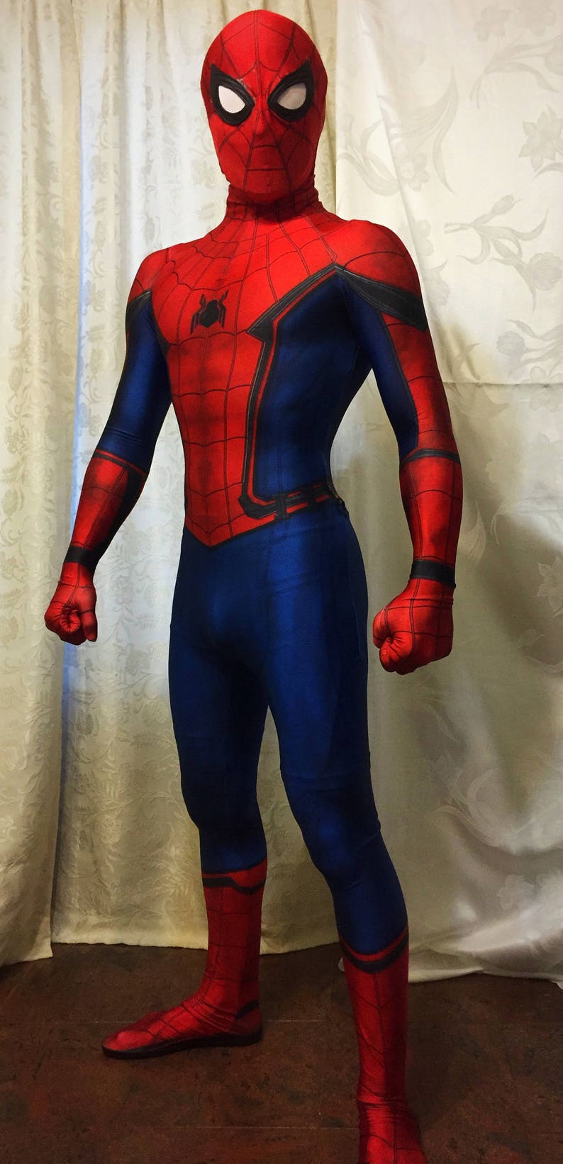 May include: A red and blue spandex costume of Spider-Man with a black spider logo on the chest. The costume has a red mask with black eyes.