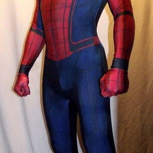 May include: A red and blue Spiderman costume with a black spider logo on the chest. The costume has a red mask with black eyes and a web pattern.