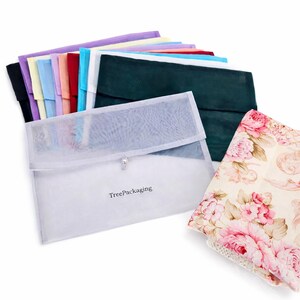 Könnte beinhalten: Eine Sammlung farbiger Stoffbeutel und ein Stoff mit floralem Muster. Die Beutel sind in verschiedenen Farben erhältlich, darunter Schwarz, Lila und Grün. Eine transparente Netztasche mit dem Text "TreePackaging" befindet sich im Vordergrund.