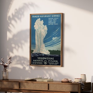 May include: Vintage travel poster for Yellowstone National Park featuring a geyser erupting against a blue sky. The poster includes the text "Ranger Naturalist Service" and "Yellowstone National Park".