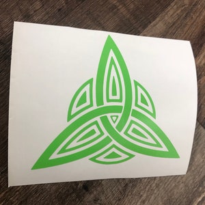 May include: A green Celtic knot design, also known as a Trinity knot, is a symbol of faith, love, and unity. The knot is made up of three interlocked loops, which represent the Father, Son, and Holy Spirit.