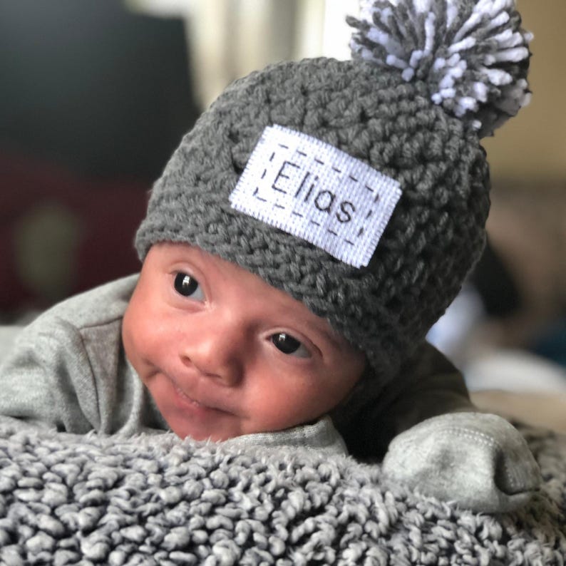 This hat has a pom pom on top and it is the color you select and white.  This beanie comes in 43 colors and the color shown is gray.