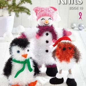 May include: The cover of "Christmas Knits Book 10" displays knitted festive characters: a snowman, penguin, and robin. The snowman has a pink hat and scarf. The penguin wears a green scarf, and the robin has a Santa hat. The book is designed by Carol Connelly.