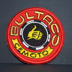May include: A red, white, and yellow embroidered patch with the text "Bultaco Cemoto" and a thumbs up symbol in the center.