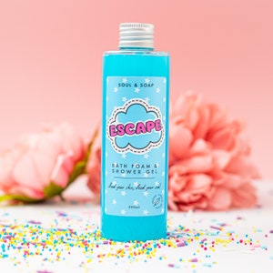 May include: A blue bottle of bath foam and shower gel with a white label that says "SOUL & SOAP ESCAPE" and "feed your skin, feed your soul". The bottle is 200 ml and is sitting on a white surface with colorful sprinkles.