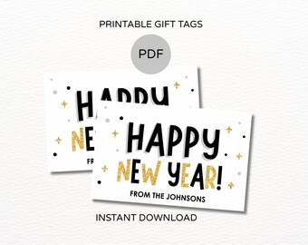 May include: Two white rectangular gift tags with the words "HAPPY NEW YEAR!" in black and gold glitter lettering. The tags also include the text "FROM THE JOHNSONS" and are decorated with gold stars and black dots. The words "PRINTABLE GIFT TAGS" and "INSTANT DOWNLOAD" are also visible.