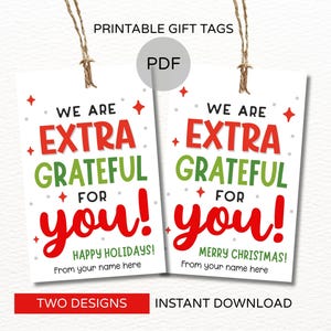 May include: Two printable gift tags with the text "WE ARE EXTRA GRATEFUL FOR YOU!" in red, green, and white. One tag says "HAPPY HOLIDAYS!" and the other says "MERRY CHRISTMAS!". Both tags have a space for a name.
