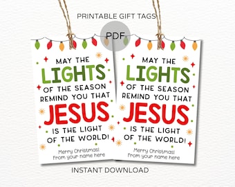 May include: Two white printable gift tags with the text "May the Lights of the Season Remind You That Jesus is the Light of the World!" in green and red. The tags are decorated with Christmas lights and stars.