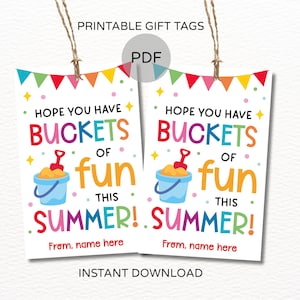 May include: Two printable gift tags with the text "Hope you have buckets of fun this summer!" in colorful letters. Each tag features a bucket and shovel graphic. The tags are white with a string for hanging.