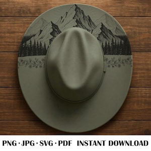 Op de afbeelding: Een saliegroene fedora hoed met een brede rand. De hoed heeft een zwart-wit bergketenontwerp op de rand. De tekst "PNG • JPG • SVG • PDF • DIRECTE DOWNLOAD" staat onderaan.