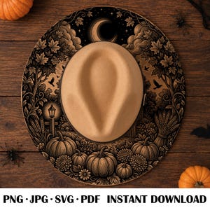 May include: A tan felt fedora hat featuring a wide brim with a detailed black graphic print of a night scene including pumpkins, maple leaves, a crescent moon, stars, a lantern, and birds. The hat is centered on a dark wooden surface.