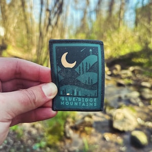 May include: A dark green patch with a white crescent moon and a silhouette of a mountain range. The text "BLUE RIDGE MOUNTAINS" is printed in white on the patch.