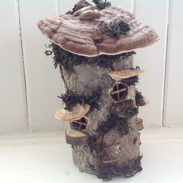 Handmade woodland fairy house from log, fungus, tree bark.