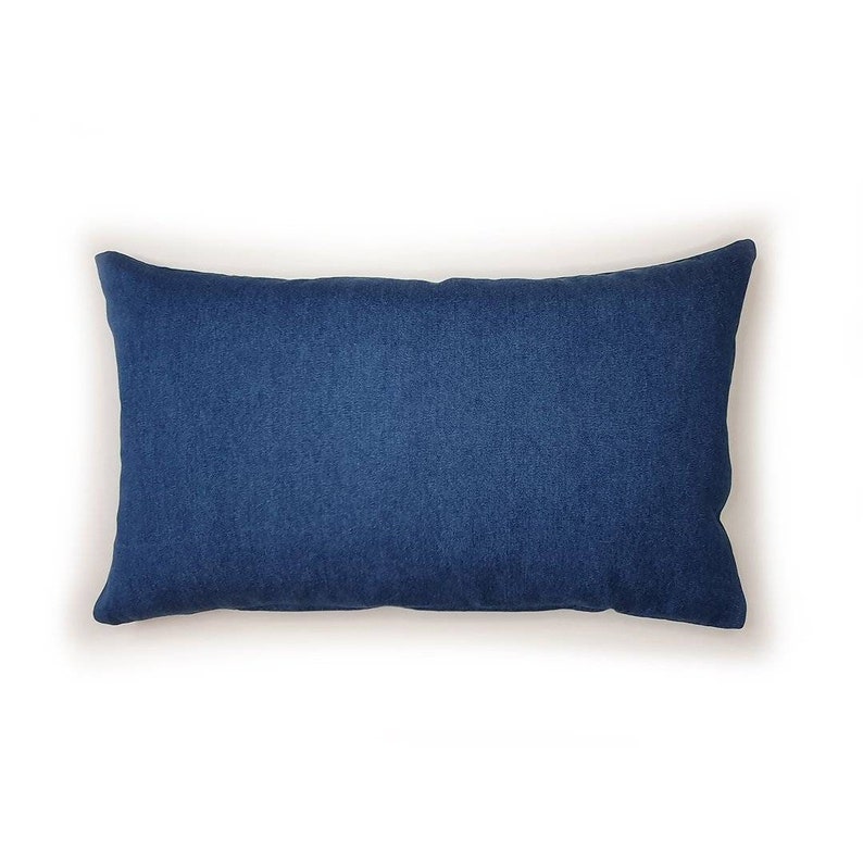 K&ouml;nnte beinhalten: Ein rechteckiges blaues Kissen mit weichem, strukturiertem Stoff.