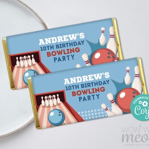 May include: Two blue and white chocolate bar wrappers with a bowling theme. The wrappers feature a bowling lane with bowling pins and a bowling ball. The text on the wrappers reads "Andrew's 10th Birthday Bowling Party".