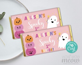 May include: Two pink candy bar wrappers with gold foil edges. Each wrapper features the text "ALLISON'S Spooky 1st BOO-DAY" and a cartoon ghost with a magic wand. One wrapper has a stack of pumpkins.