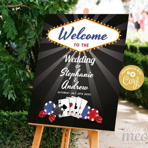 May include: Black and white wedding welcome sign with a Vegas-style sign that says "Welcome to the Wedding of Stephanie & Andrew" with a date and playing cards and dice.