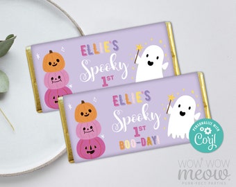 May include: Two lavender candy bar wrappers with gold foil edges, featuring Halloween designs. The wrappers display stacked pumpkins, a ghost with a wand, and the text "Ellie's Spooky 1st Boo-Day!"