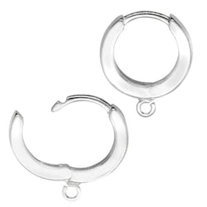 Op de afbeelding: Twee zilverkleurige oorringen. Elke oorring heeft een scharniersluiting en een kleine lus aan de onderkant voor het bevestigen van bedels of andere decoratieve elementen. De oorbellen worden tegen een witte achtergrond getoond.
