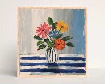 May include: A framed painting of a floral still life. A white vase with blue stripes holds colourful flowers in shades of red, orange, yellow, and blue. The flowers sit on a blue and white striped surface.