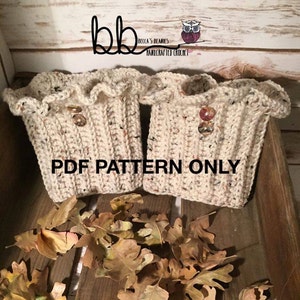 Op de afbeelding: Een paar beige gebreide laarsmanchetten met een gerimpelde bovenkant en een knoopdetail. De manchetten liggen op een houten oppervlak met herfstbladeren eromheen. De tekst "PDF PATTERN ONLY" is op de afbeelding gedrukt.