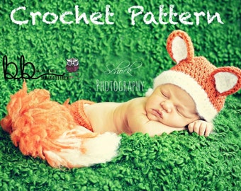 May include: A newborn baby wearing a crocheted fox hat and matching pants. The hat has white ears and a white brim. The baby is sleeping on a green fuzzy surface. The image includes the text "Crochet Pattern" and "Schrock Photography".
