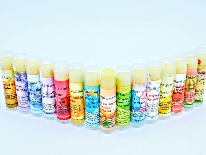 May include: A collection of 16 colorful lip balms in tubes, each with a different flavor and design. The lip balms are arranged in a semi-circle on a white background. The flavors include Coconut, Grape, Blueberry, Earl Grey, Cherry, Pumpkin, Raspberry, Apricot, Cotton Candy, Birthday Cake, Watermelon, Strawberry, and Vanilla.