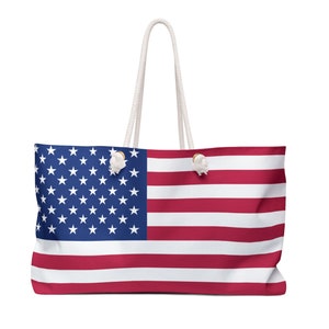 Peut inclure: Un grand sac fourre-tout avec le drapeau américain. Le sac présente un champ bleu avec des étoiles blanches et des rayures rouges et blanches. Il a des poignées en corde blanche, parfait pour transporter des articles.