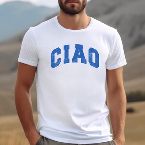 May include: White t-shirt with a blue "CIAO" graphic printed on the front.