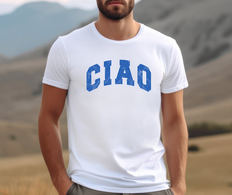 May include: White t-shirt with a blue "CIAO" graphic printed on the front.