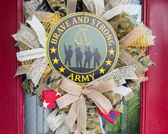 May include: A patriotic wreath with a central circular emblem that reads "Brave and Strong ARMY." The wreath features camouflage, burlap, and ribbon accents. The design includes stars, silhouettes of soldiers, and text elements like "Freedom" and "Hero."
