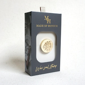 May include: A gold wax seal stamp with a leaf design in a black box with the text "Made of Honour" and "Wax seal stamp".