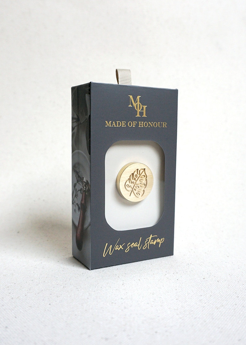 May include: A gold wax seal stamp with a leaf design in a black box with the text "Made of Honour" and "Wax seal stamp".