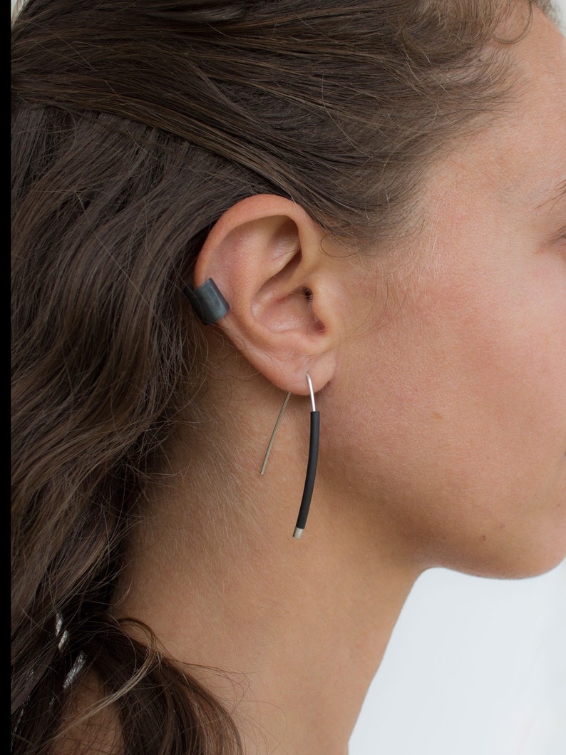 a smouth fitted ear cuff of Silver 925, placed around the earlobe. A light weight black ear cuff. the length is 10 cm.