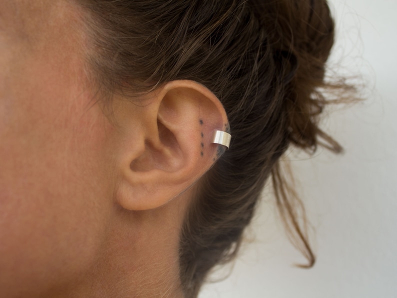 a smouth fitted ear cuff of Silver 925, placed around the earlobe. A light weight ear cuff with a matt finish. The lenght is 5 cm.