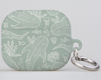 May include: A light green Airpod case with a white outline design of whale sharks, jellyfish, and seaweed. The case has a silver metal ring attached to it.