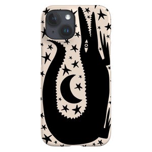 May include: A phone case featuring a black alligator silhouette on a cream backdrop. The design incorporates a crescent moon and stars. The case has a camera aperture and is designed for a smartphone.